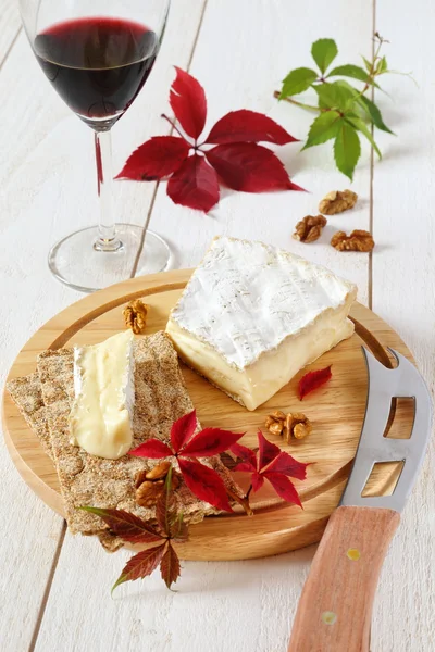 Brie, formaggio di latte vaccino francese morbido, foglie autunnali e un vino — Foto Stock