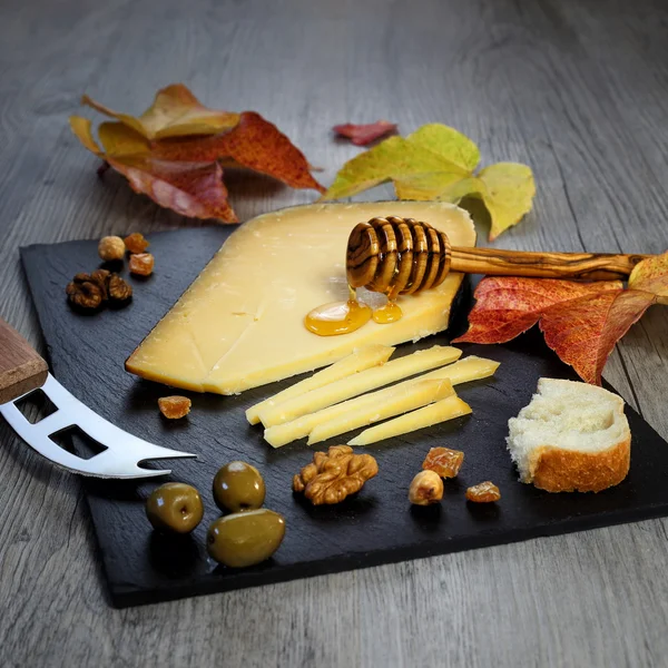 Solidní sýry deska: solidní holandský sýr, olivy a vlašské ořechy — Stock fotografie