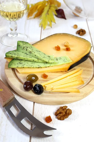 Sajttál: szilárd sajt, olajbogyó, dió és borospohár — Stock Fotó