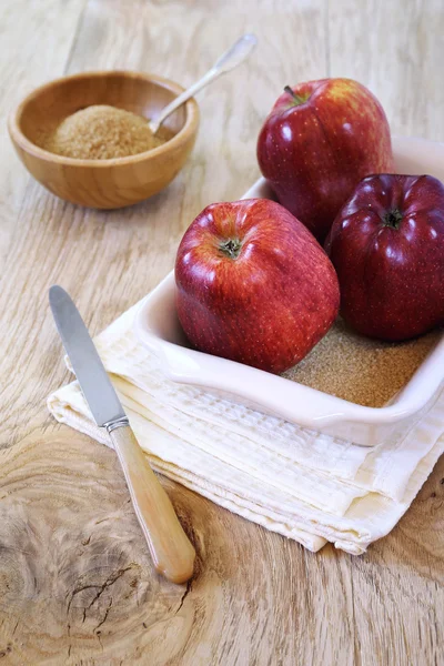 Three red apple in baking dish and brown sugar — Stock Photo, Image