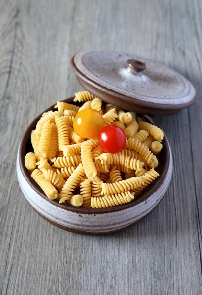 Pasta fusilli and two cherry tomatoes — 스톡 사진