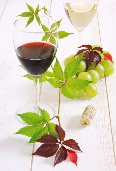 Бокалы красного вина, белое вино и букет зеленого винограда — стоковое фото