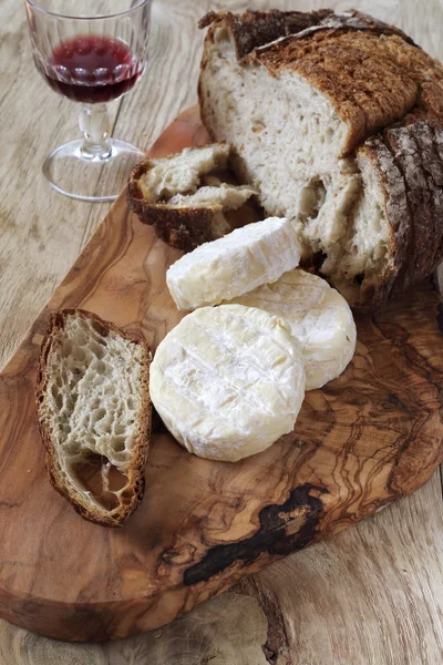 Goat cheese, country  bread and wineglass — Stock Photo, Image