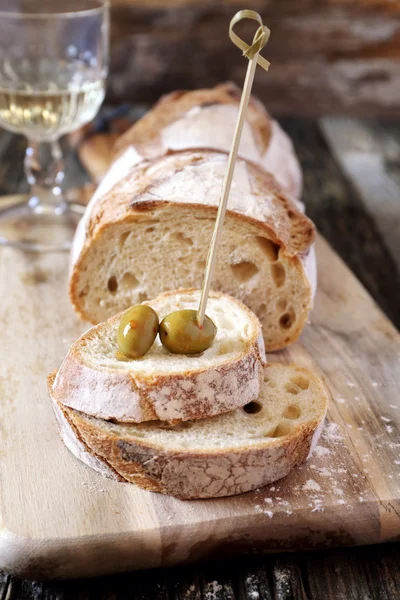 French country bread, olives and wineglass — Stock Photo, Image