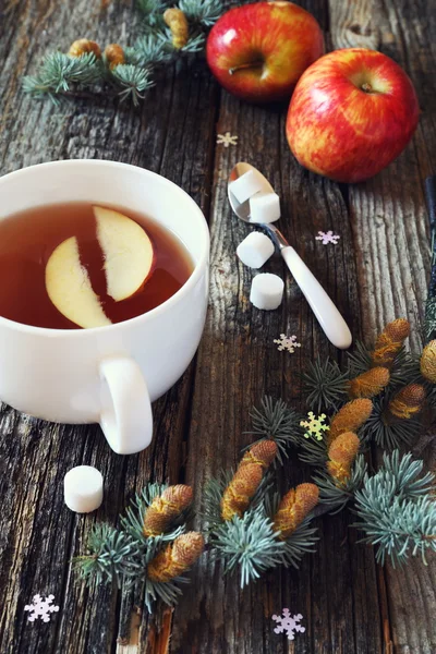 Big cup of black tea, red apples and pine branches — Stock Photo, Image