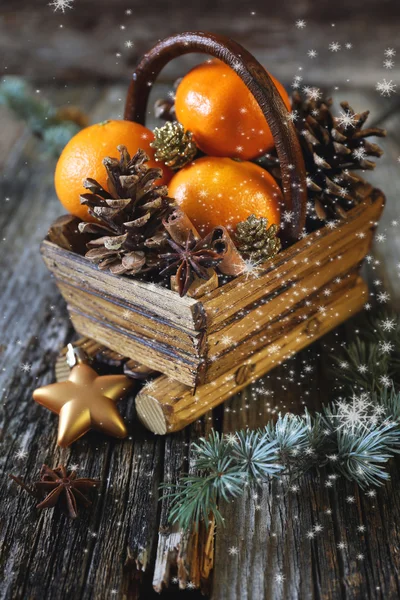 Canasta de Navidad con mandarinas, palitos de canela y conos de pino — Foto de Stock