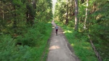 Genç bisikletçi güzel bir yolda gidiyor.