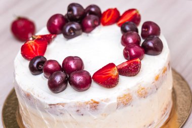 Çilek ve kiraz, hindistan cevizli cheesecake 'in üstünde..