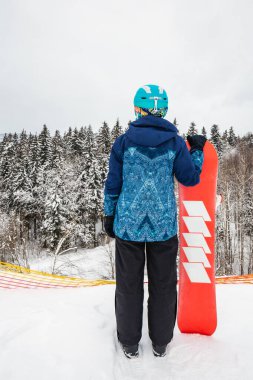 Kayak merkezinde snowboard yapan biri.