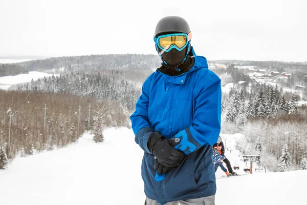 Persona con una tabla de snowboard en la estación de esquí —  Fotos de Stock