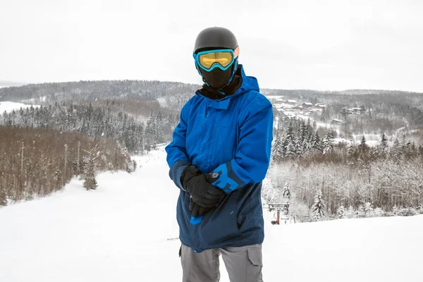 Persona con una tabla de snowboard en la estación de esquí —  Fotos de Stock