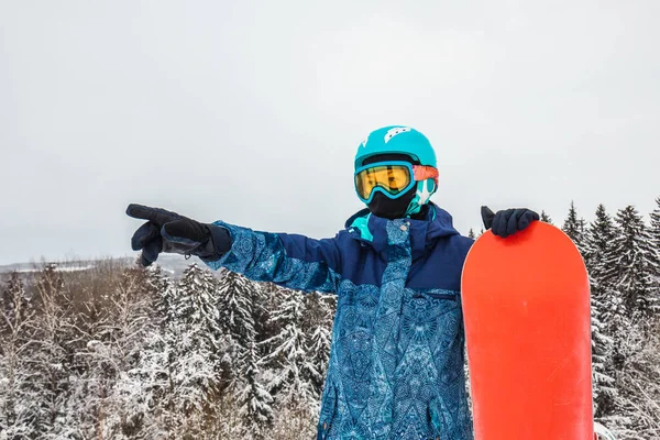 Persona con una tabla de snowboard en la estación de esquí —  Fotos de Stock