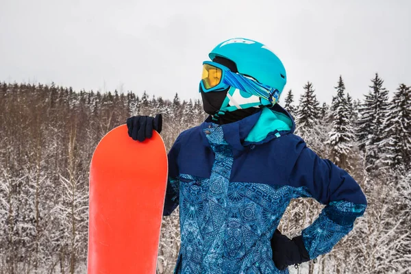 Persona con una tabla de snowboard en la estación de esquí —  Fotos de Stock