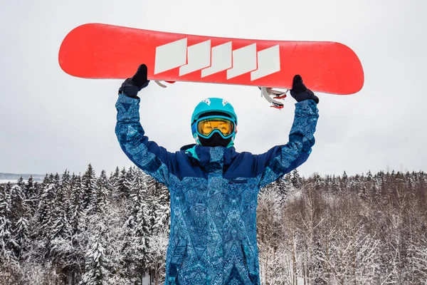 Persona con una tabla de snowboard en la estación de esquí —  Fotos de Stock