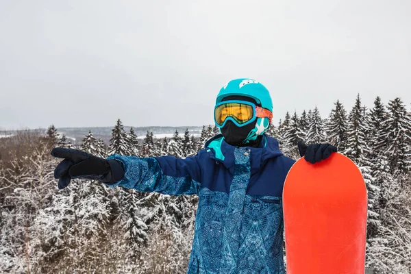 Persona con una tabla de snowboard en la estación de esquí —  Fotos de Stock