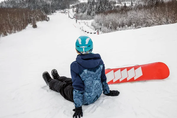 Persona con una tabla de snowboard en la estación de esquí —  Fotos de Stock