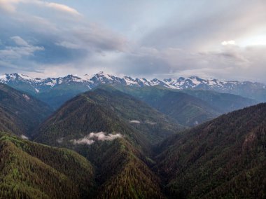 Bulutlar ve yeşil ormanlarla Ushba Dağı 'nın havadan görünüşü. Kafkas Dağları, Gürcistan 'ın Svaneti bölgesi.