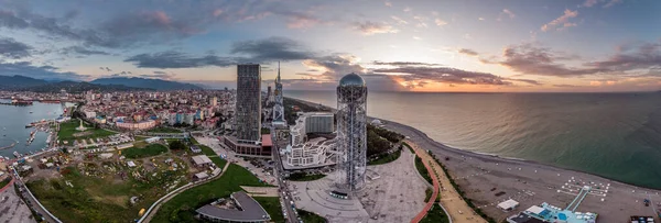 Batum 'un deniz kenarındaki hava aracının güzel bir gün batımı ışığıyla görüntüsü. Dağ ve deniz geçmişi olan modern binalar..