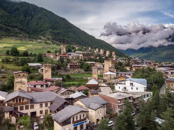 Arka planda tipik kule evleri ve karlı dağları olan Mestia köyünün hava manzarası. Yukarı Svaneti, Georgia.