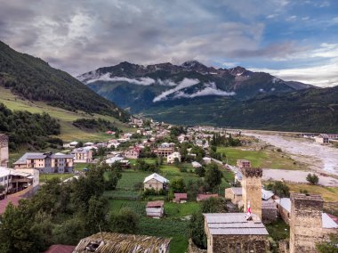 Arka planda tipik kule evleri ve karlı dağları olan Mestia köyünün hava manzarası. Yukarı Svaneti, Georgia.