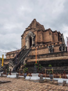Chiang Mai, Tayland 'daki Wat Chedi Luang harabeleri, bulutlu bir gökyüzünün altında. Bu antik Budist tapınağında geleneksel Lanna mimarisi, dekoratif ayrıntılar ve tarihi ihtişam sergileniyor..
