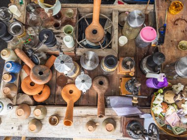 Tayland 'da hareketli bir market tezgahının genel bakış açısında çeşitli antika kahve demleme araçları seramik çömlek ve kırsal ahşap üzerine geleneksel el sanatları koleksiyonları sergileniyor..