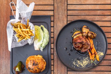 İrlanda viskisi soslu hamburger ve fileto biftek. Pişmiş havuç ve fırında patatesle servis edilir. Antalya, Türkiye - 20 Nisan 2022.