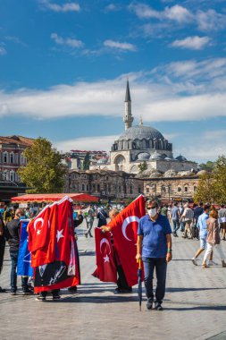Türkiye 'nin İstanbul kentindeki Eminonu Meydanı' nın merkezinde geleneksel Türk Bayrağı satıcısı. İstanbul, Türkiye - 30 Eylül 2020.
