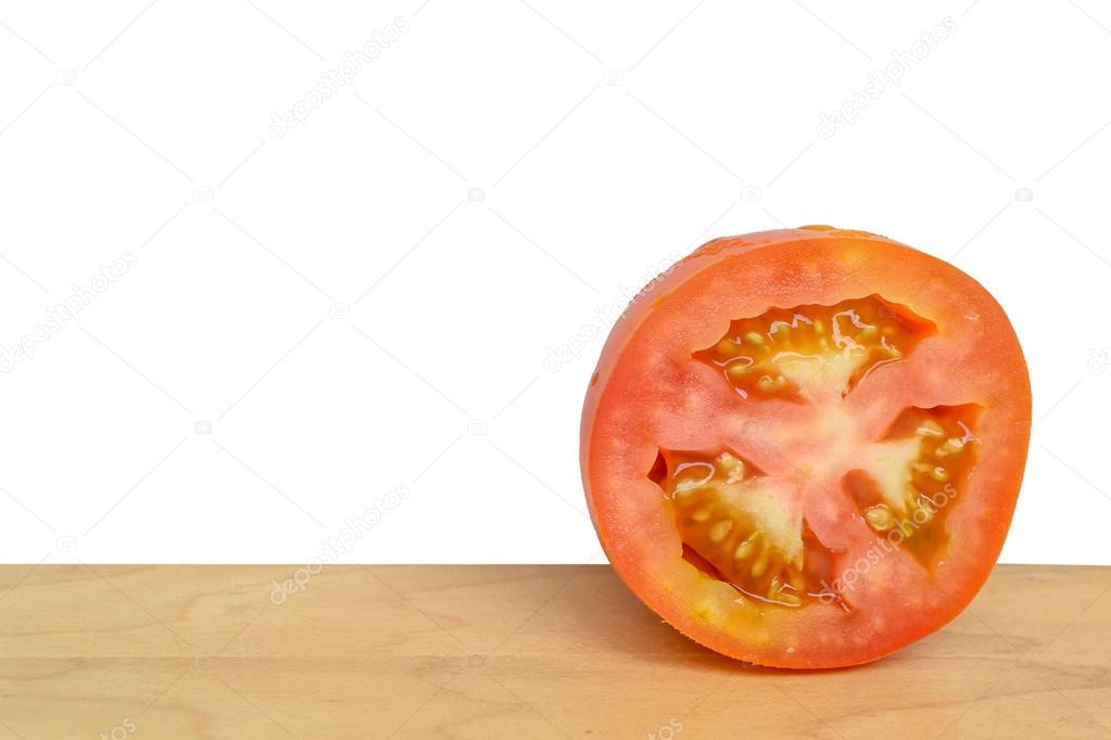 Tomato slice isolated on wood table with white background
