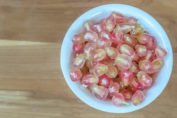 ahşap masa arka plan üzerinde pembe nar meyve.