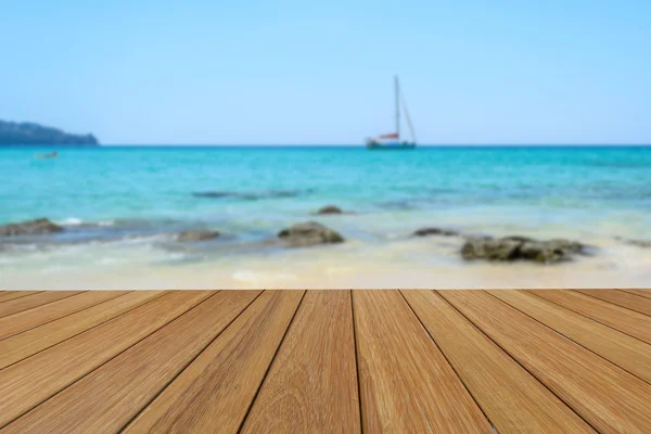 Trä bordsskiva på suddig yacht och vit sandstrand bakgrund för presentation produkt. — Stockfoto