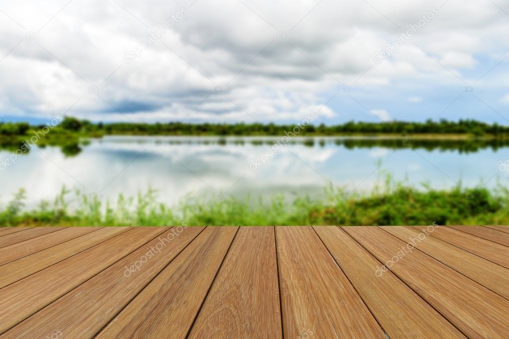 Wood table top on blurred Lake and sky background for presentation product.