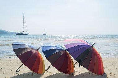 colorful of beach umbrella with sky and beach background clipart