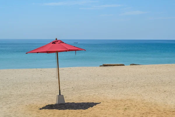 Sombrilla roja en la playa con fondo azul cielo — Foto de Stock