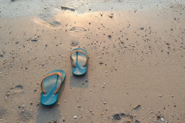 gün batımında kum plaj zemin üzerine terlik