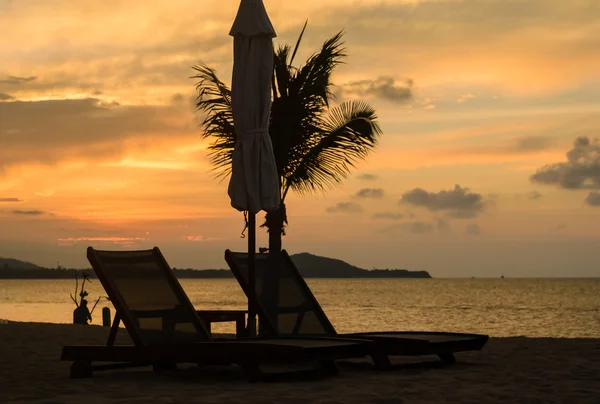 Пляжные стулья на пляже с белым песком и закатом — стоковое фото