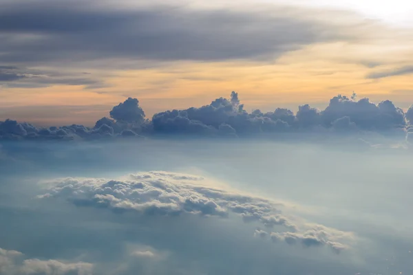 Gökyüzü ve gün batımı görünümü üzerinden uçak bulutların üstünde