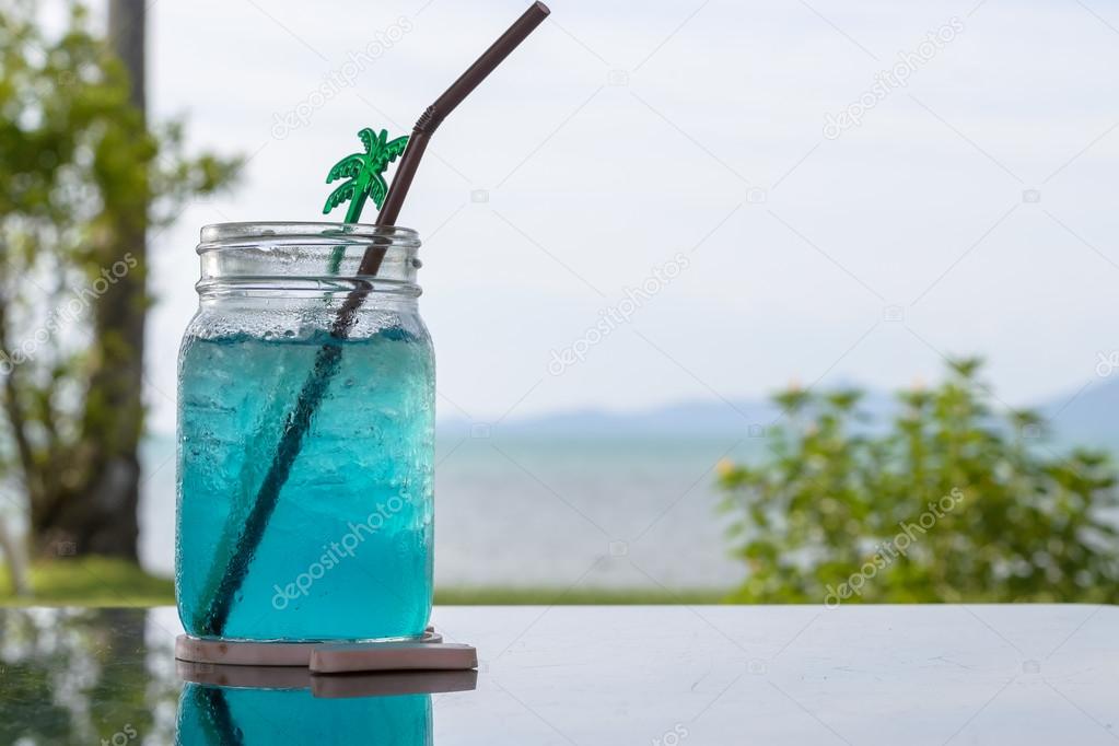 blue lemon soda on black stone table with blur beach background