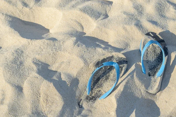 Pantofole con lo sfondo spiaggia di sabbia — Foto Stock