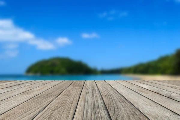 Trä table top med suddiga natur scen tropisk strand och blå himmel bakgrund — Stockfoto