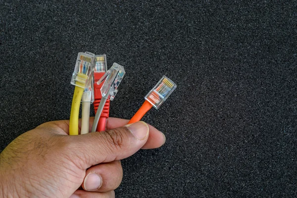 Mano sosteniendo cables coloridos de Internet — Foto de Stock