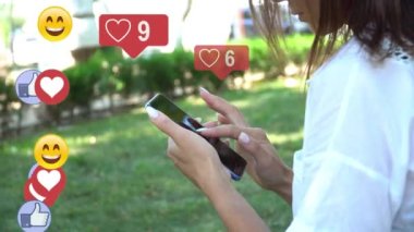 Güzel, genç ve güzel bir kız akıllı bir telefonla iletişim kuruyor, telefon ekranına metin yazıyor, sosyal ağ simgeleri aynı abone sayısına sahip, hızla artıyor