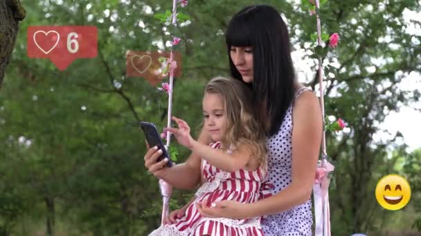 Una mujer joven con un niño usa un teléfono, animación con gustos de interfaz de usuario, seguidores, comentarios para redes sociales desde un teléfono inteligente. — Vídeo de stock