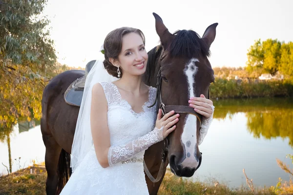 Noiva jovem e noivo, andar em uma fazenda com cavalos — Fotografia de Stock