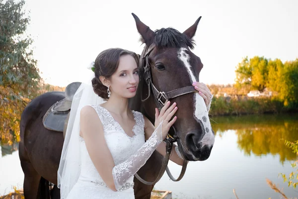 Fiatal menyasszony és a vőlegény, sétáljon egy farm lovakkal — Stock Fotó