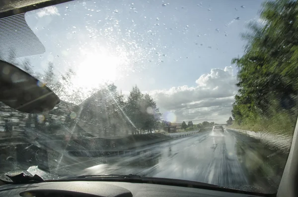 Carro indo rápido em uma auto-estrada molhada — Fotografia de Stock