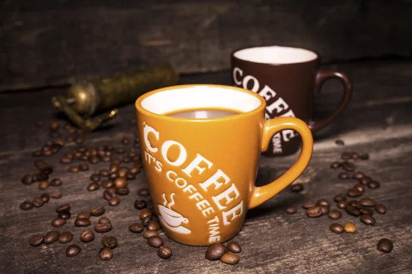 Kaffeetasse mit Kaffeebohnen auf Holzgrund — Stockfoto