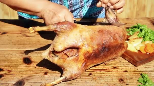 Carne de ganso assada sendo cortada na mesa de madeira — Vídeo de Stock