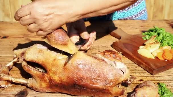 Carne de ganso assada sendo cortada na mesa de madeira — Vídeo de Stock