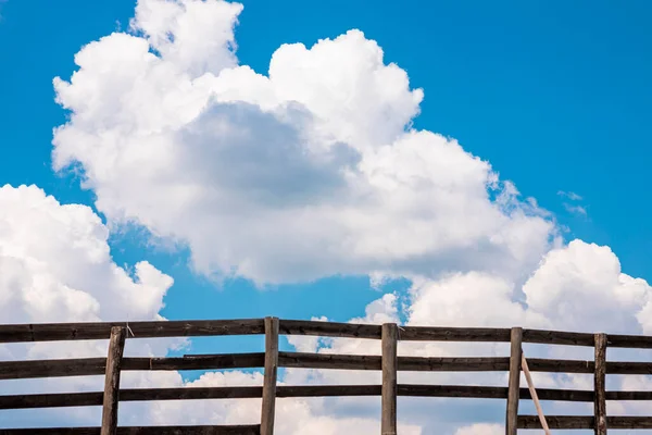 Mavi Gökyüzü Beyaz Kabarık Bulutlar Ahşap Çitin Arkasında — Stok fotoğraf